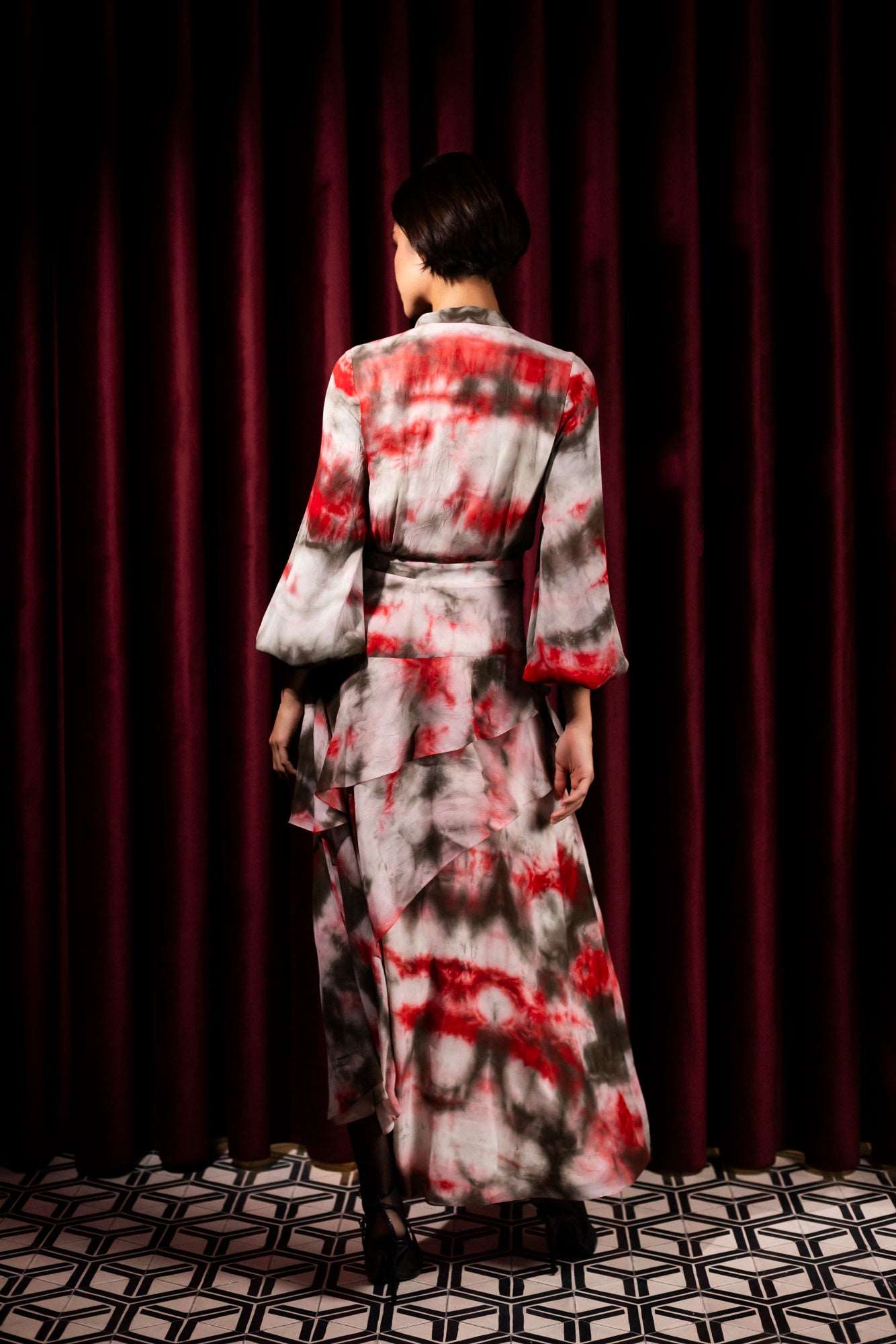 John'N Jack - La robe Aimée  est confectionnée dans un luxueux voile de viscose imprimé tie-dye exclusif. Sa silhouette se caractérise par une allure gracieuse de mouvement et d'élégance ainsi que des manches ballons fluides. Un must pour les garde-robes luxueuses et modernes.